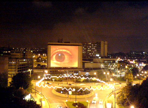image shows a projected eye onto the side of a large building in Bradford City centre