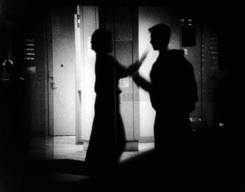 Film still showing a man and a woman silouetted. in black and white